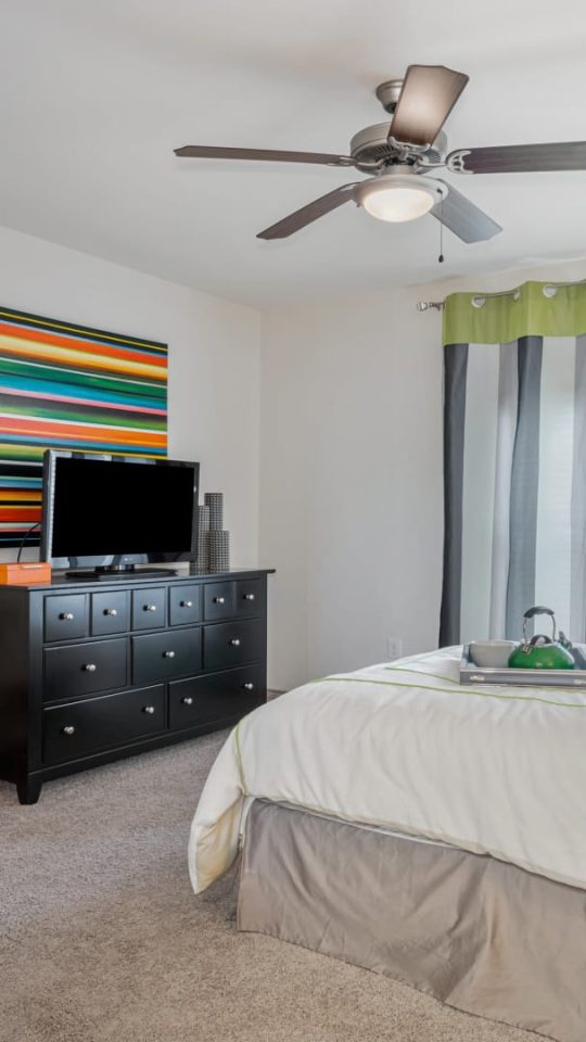 a bedroom with a bed, dresser, and television at The  BLVD